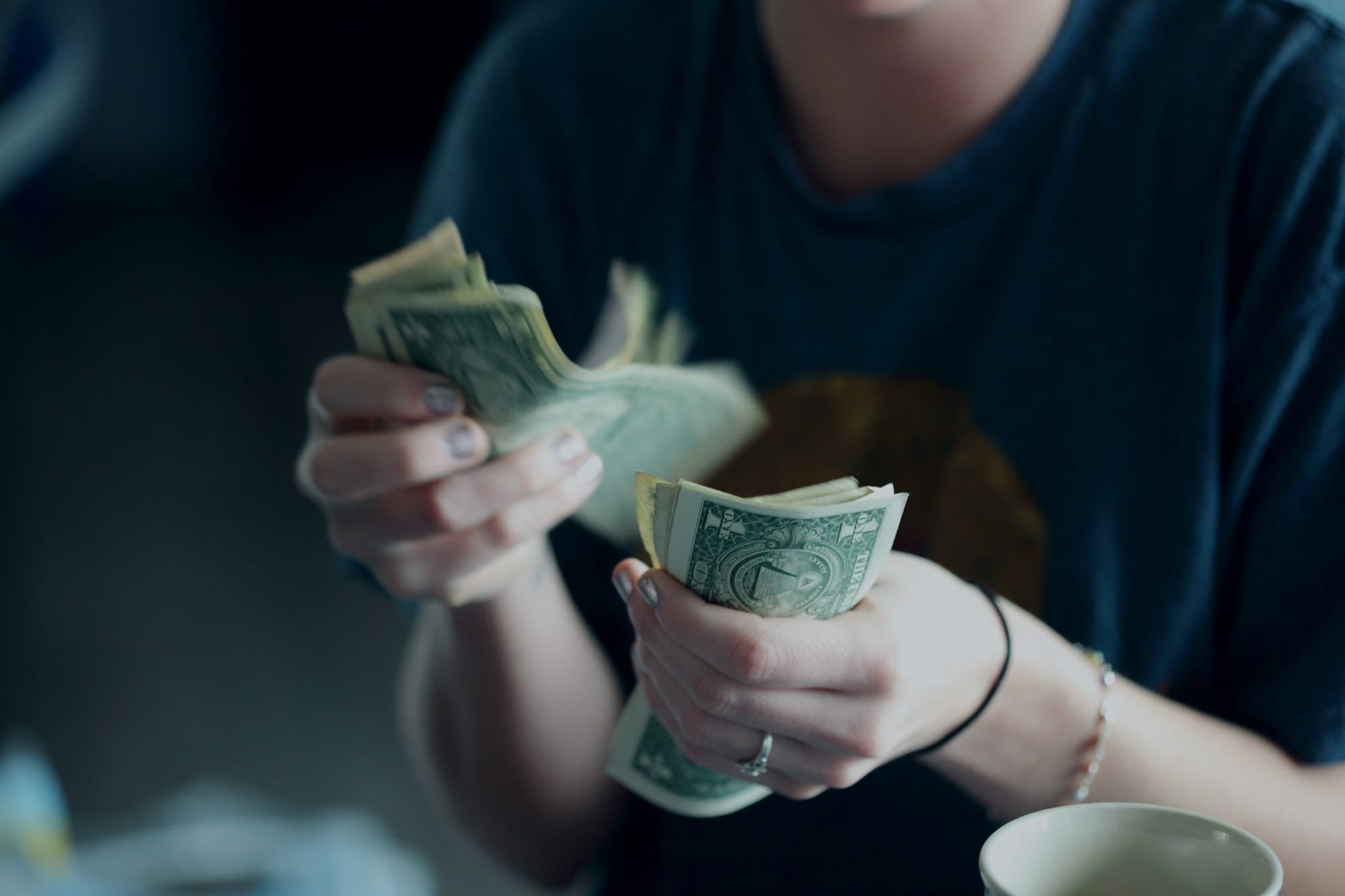 A parent and teen writing a spending plan on paper